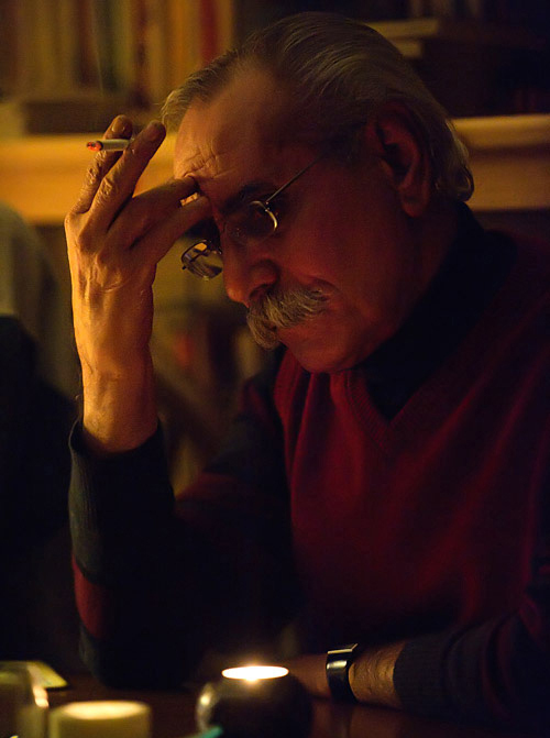 Nozar Azadi in warm lamplight, holding a cigarette